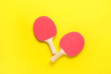 Sarı arka planda kırmızı ping pong raketleri