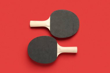 Kırmızı arkaplanda siyah ping pong raketleri