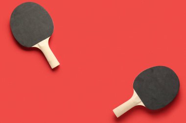 Kırmızı arkaplanda siyah ping pong raketleri