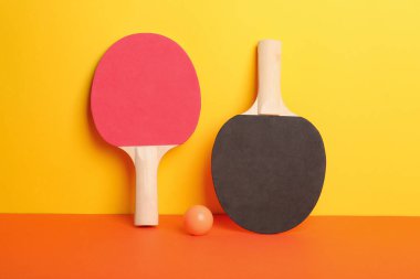 Farklı masa tenisi raketleri ve renk arkaplan üzerinde top