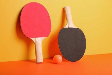 Farklı masa tenisi raketleri ve renk arkaplan üzerinde top