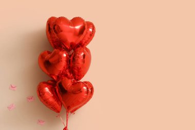 Heart-shaped balloons on beige background. Valentine's Day celebration