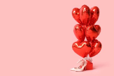 Kalp şeklinde balonlar hediye kutuları, taç ve pembe arka planda topuklu ayakkabılar. Sevgililer Günü kutlaması
