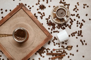 Kumda sıcak Türk kahvesi, gri arka planda fincanlar ve fasulyeler.