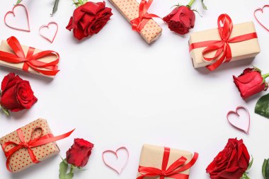 Kağıt kalpli hediye kutuları ve beyaz arka planda gül çiçeklerinden yapılmış çerçeve. Sevgililer Günü kutlaması