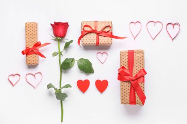 Süslü kalpli hediye kutuları ve beyaz arka planda gül çiçekleri. Sevgililer Günü kutlaması