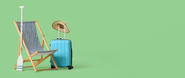 Güverte sandalyesi, kürek ve bavul yeşil arka planda, mesaj için yer var. Turizm konsepti