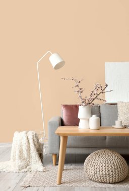 Gri kanepesi, masası ve lambası olan oturma odasının içinde.