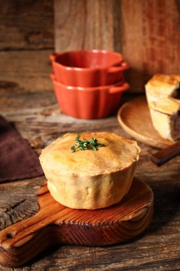 Ahşap zemin üzerinde lezzetli etli turta olan tahta.