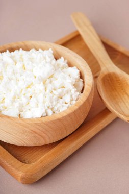 Bej arka planda lezzetli süzme peynirli kase