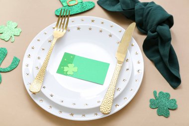 Beautiful table setting for St. Patrick's Day celebration on beige background