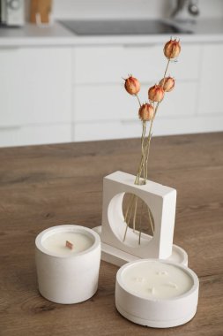 Açık mutfakta, masada kurumuş çiçekler ve mumlar, yakın plan.