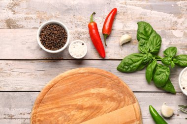 Kesme tahtası, taze otlar ve hafif ahşap arka planda baharatlar ile kompozisyon