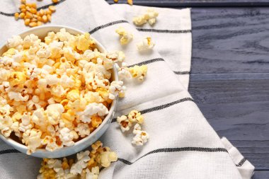 Mavi ahşap arka planda lezzetli patlamış mısır kasesi.