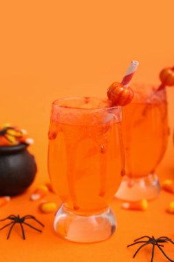 Cadılar Bayramı için lezzetli kokteyller. Mısır şekeri ve turuncu arka planda örümcekler. Yakın plan.