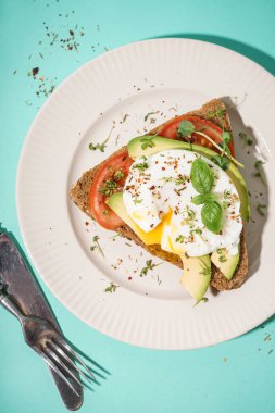 Mavi arka planda yumurtalı lezzetli bir sandviç tabağı.