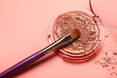 Kırmızı arkaplanda makyaj fırçası ve kırık fosforlu kalem