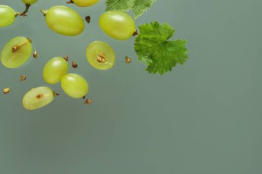 Taze yeşil üzümler, yapraklar ve tohumlarla renklendirilmiş.