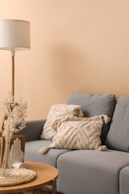 Rahat gri kanepesi ve ahşap sehpası olan modern oturma odasının içinde.