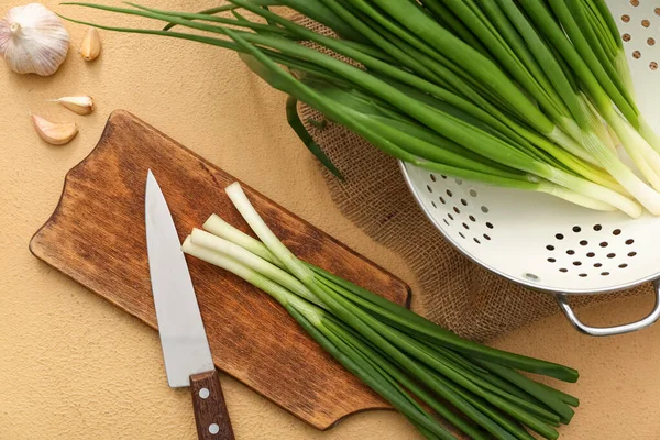 Bej arka planda taze yeşil soğanlı ahşap tahta.