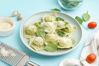 Mavi arka planda peynirli lezzetli ravioli tabağı.