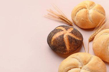 Lezzetli kayzerler ve bej arka planda buğday kulakları.