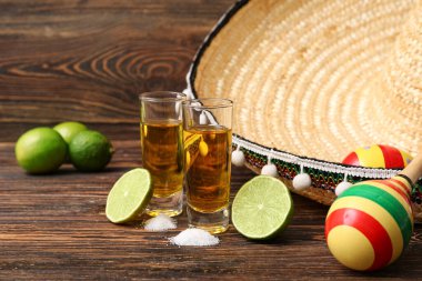 Ahşap arka planda tekila, tuz ve sombrero şapkası