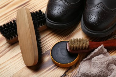Ahşap arka planda fırçalar, parlak ayakkabılar, kumaş ve ayakkabı cilası.