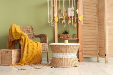 Ekoseli, kahve sehpası ve katlanır ekranlı rahat koltuklu şık bir oturma odası.