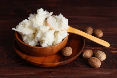 Tahta arka planda tereyağı ve fındıklı kase