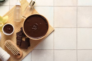 Erimiş çikolata kaseleri ve grunge fayans arka planında kozmetik ürünler içeren spa kompozisyonu