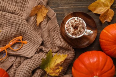 Ahşap zemin üzerinde kakao, kazak ve balkabağı dolu sonbahar kompozisyonu