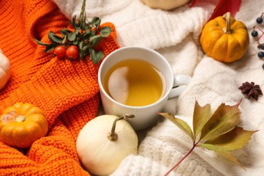 Arka planda yeşil çay, balkabağı ve yapraklı sonbahar kompozisyonu