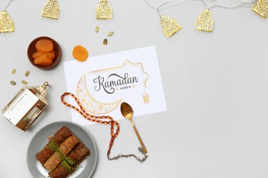 Tebrik kartı, tespih, baklava ve gri arka planda kurumuş kayısılar. Ramazan kutlaması