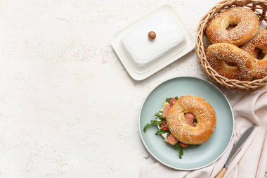 Beyaz zemin üzerinde somon balığı ve roka olan lezzetli simit sandviçi.