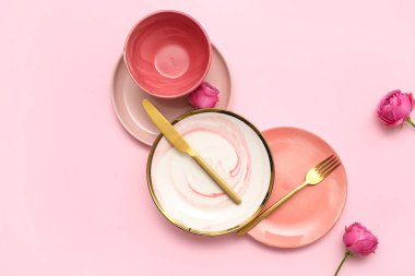 Pembe arka planda güzel gül çiçekleri olan şık bir masa.