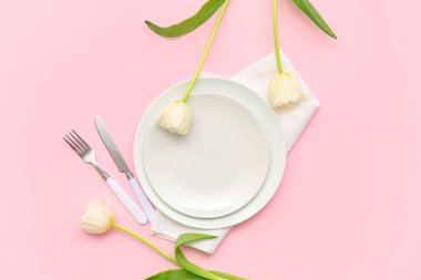 Pembe arka planda güzel lale çiçekleri olan şık masa ayarı