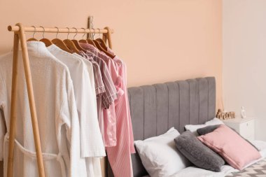 Yatak odasının içinde rahat bir yatak ve askılık.