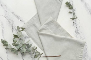 Beyaz grunge arka planda okaliptüs dalları olan gri peçete