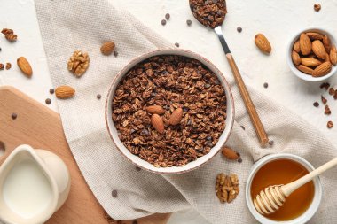 Beyaz arka planda çikolatalı mısır gevreği ve fındıklı kase.