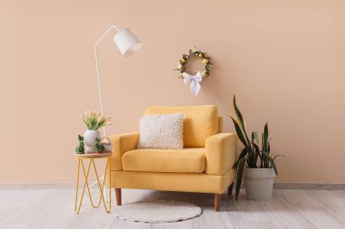 Oturma odası, koltuk, masa ve Paskalya çelengi.