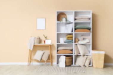 Odanın bulanık görünümü raf ünitesi, masa ve yastıklarla