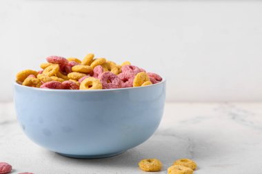 Hafif arka planda lezzetli mısır gevreği halkaları olan bir kase