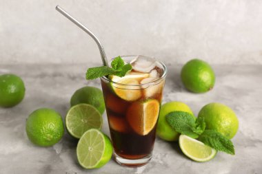 Gri arka planda naneli ve limonlu soğuk Küba Libre kokteyli.