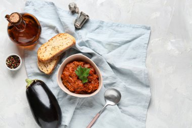 Hafif arka planda ekmek dilimleriyle servis edilen bir kase sebze yahnisi.