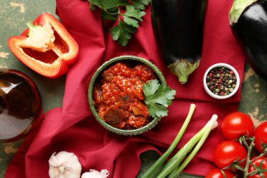 Yeşil grunge arka planda patlıcanlı, domatesli ve otlu sebze güveci.