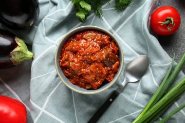 Bowl of vegetable stew with eggplant and ingredients on blue napkin