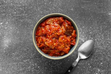 Bowl of vegetable stew with eggplant and tomatoes on grey grunge background