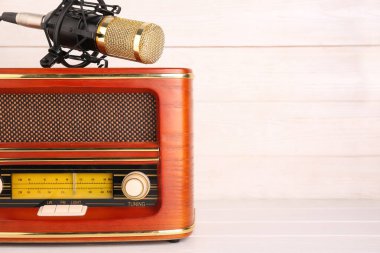 Beyaz ahşap arka planda mikrofonu olan klasik radyo alıcısı