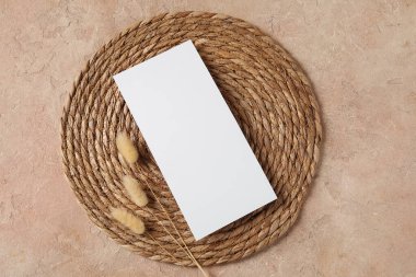 Boş kartlı hasır paspas ve bej grunge arkaplanda kurutulmuş lagurus